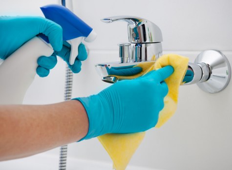 Local technician cleaning a sofa in a Soho flat with careful access
